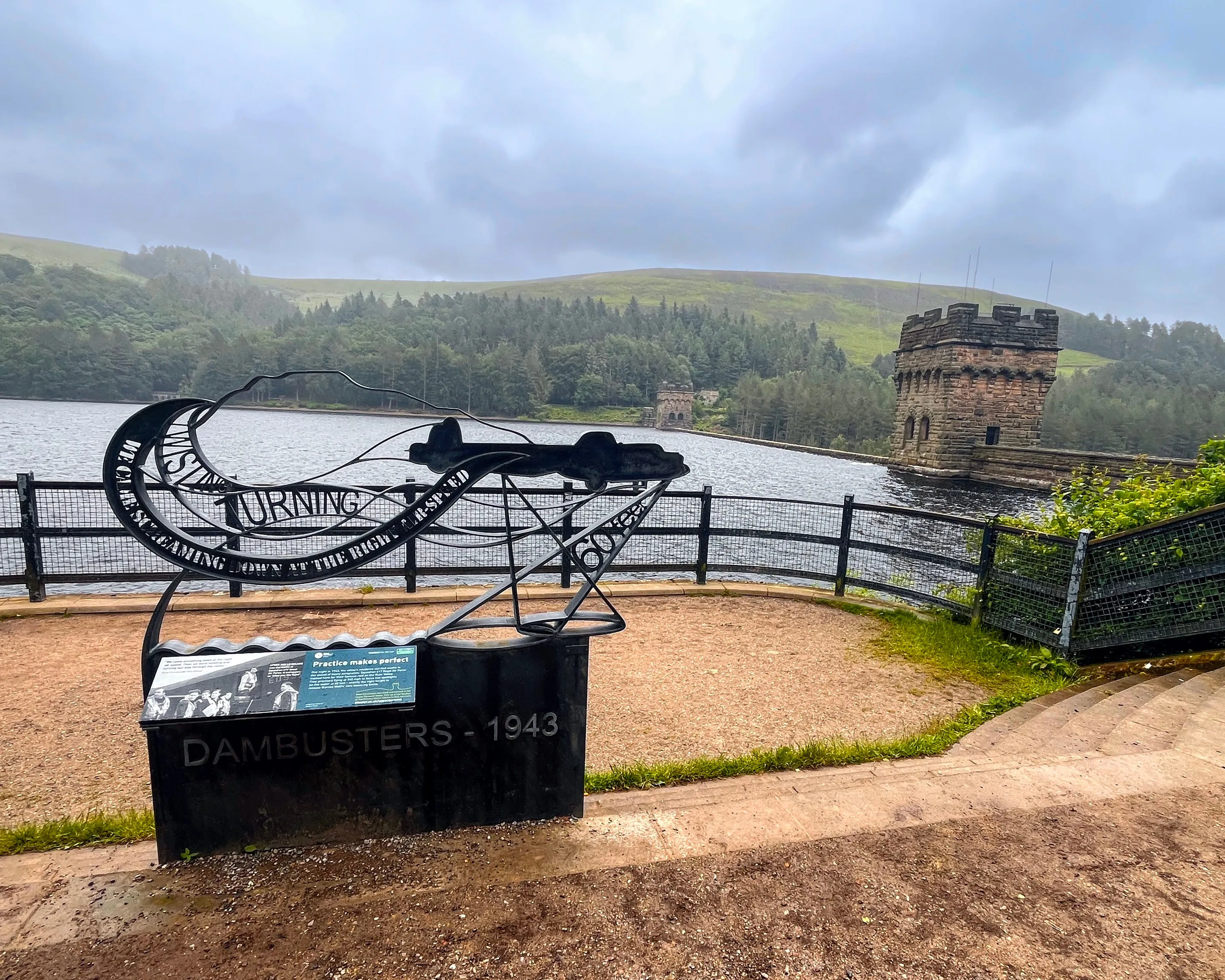 A photo of a iron memorial with dam in background