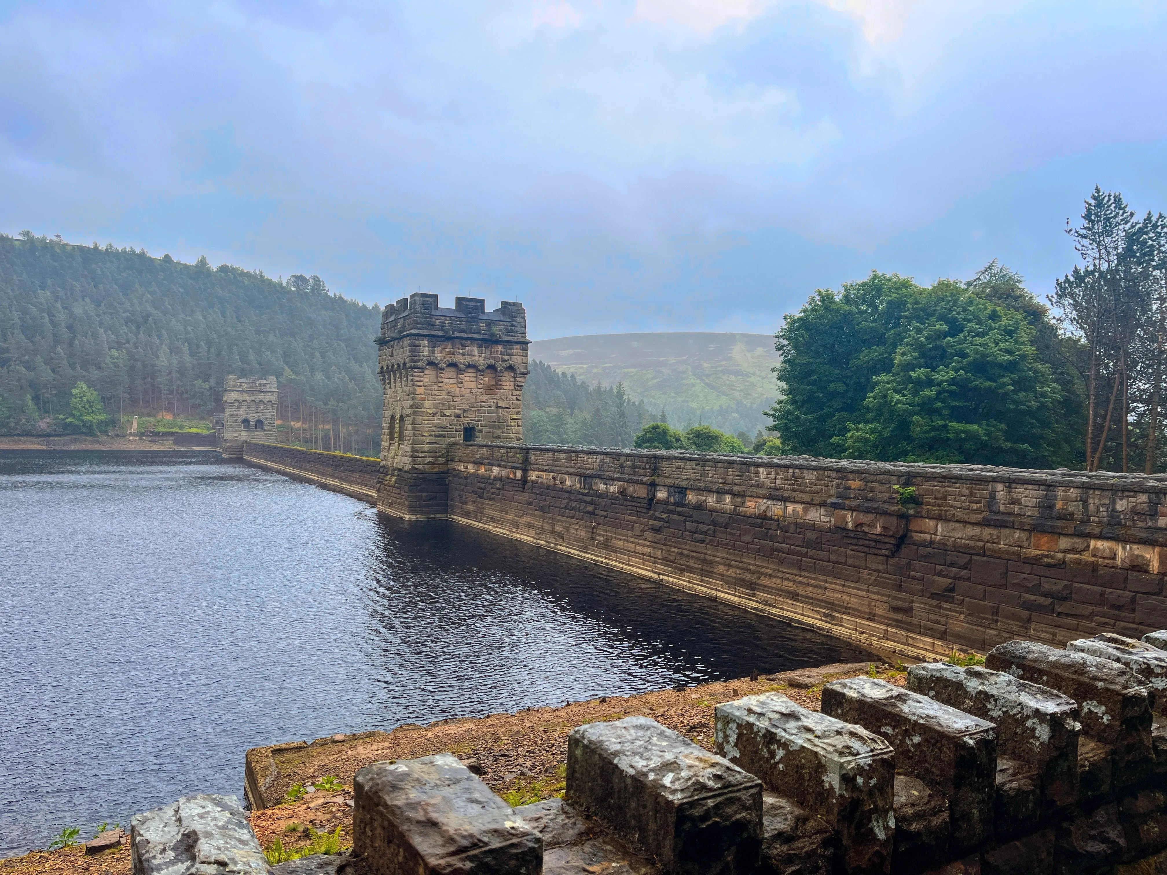 A photo of two towers with a wall between them holding back water